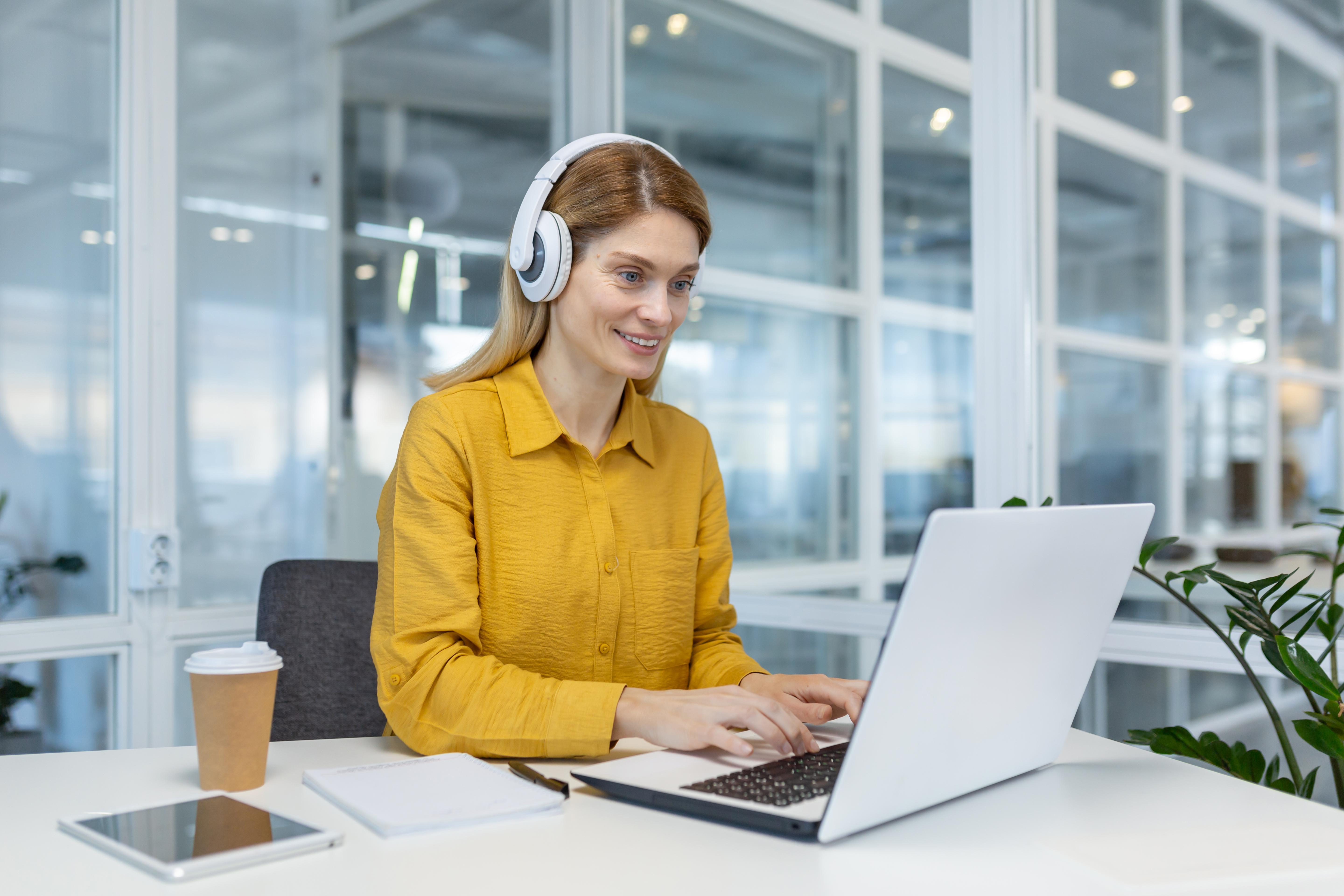 woman-programmer-working-remotely-with-laptop-headphones-modern-office-setting-1-1